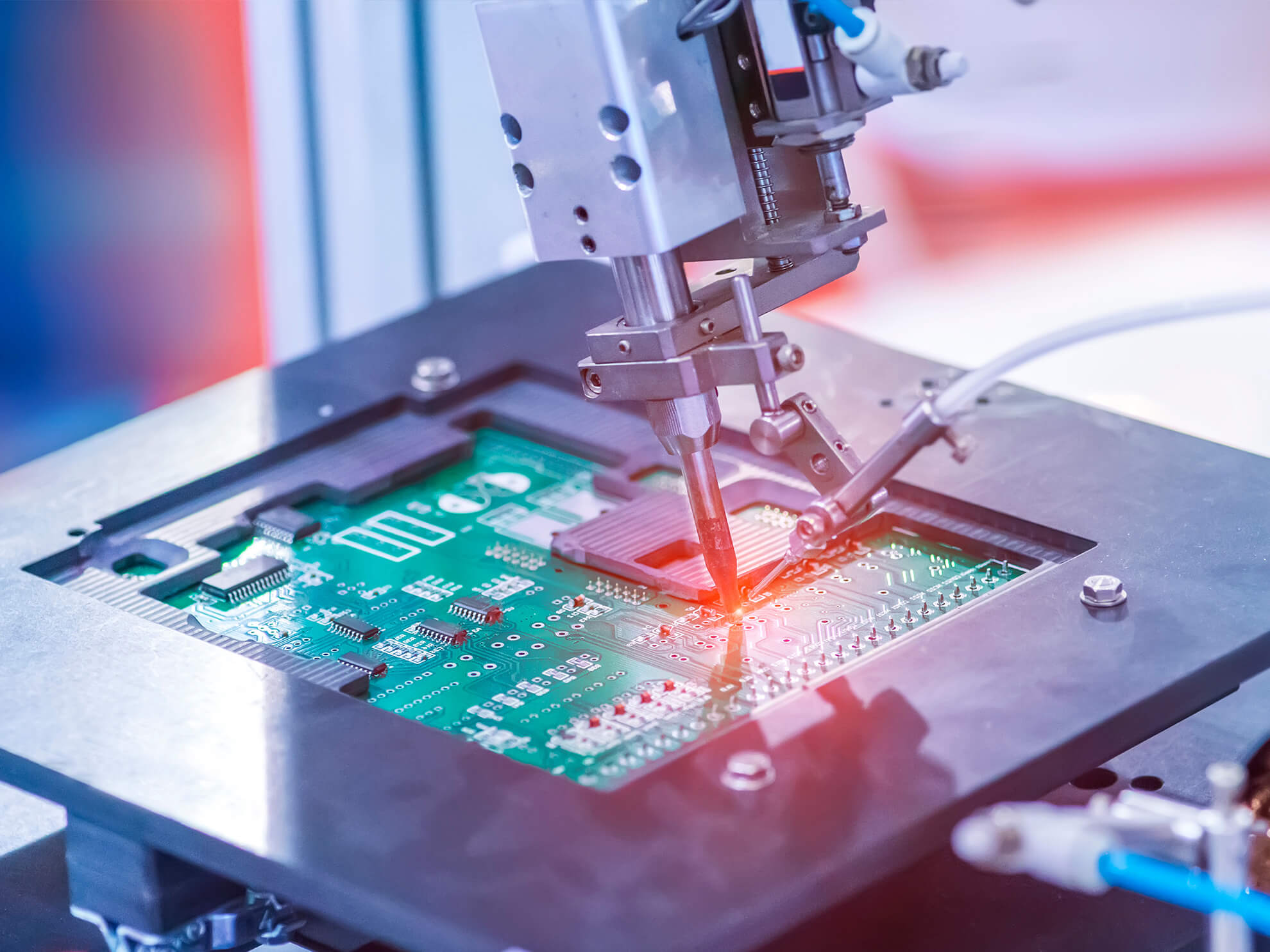 Automated SMT machine soldering components onto a green circuit board.