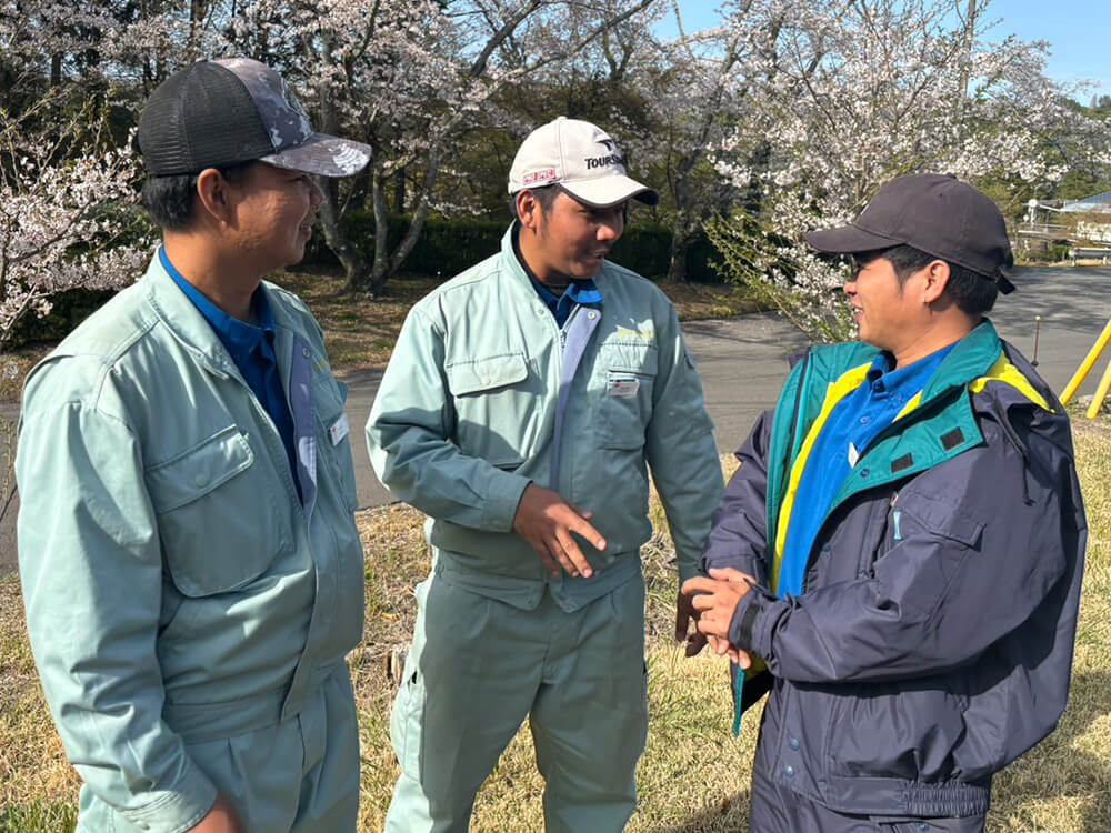 3人の作業員が屋外で話している
